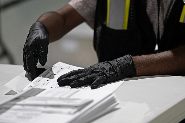 In this Sept. 3, 2020, file photo, a worker prepares absentee ballots for mailing at the Wake County Board of Elections in Raleigh, N.C. A federal appeals court has ruled that North Carolina can accept absentee ballots for more than a week after Election Day as long as they were postmarked by Nov. 3./Credit:	Gerry Broome/AP