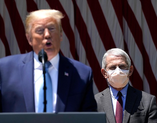 President Donald Trump is flanked by Dr. Anthony Fauci, director of the National Institute of Allergy and Infectious Diseases while speaking about coronavirus vaccine development in the Rose Garden of the White House on May 15, 2020 in Washington, DC./Credit:	Drew Angerer/Getty Images