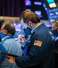 In this photo provided by the New York Stock Exchange, Benjamin Tuchman, center, works with fellow traders on the floor on November 11, 2020.
Credit: Courtney Crow/New York Stock Exchange/AP
