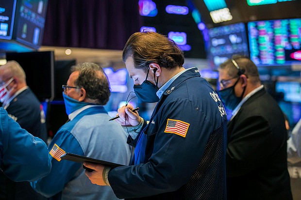 In this photo provided by the New York Stock Exchange, Benjamin Tuchman, center, works with fellow traders on the floor on November 11, 2020.
Credit:	Courtney Crow/New York Stock Exchange/AP