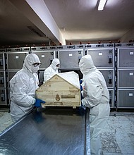 Officials with protective suits carry a coffin of a coronavirus victim before the process of ghusl, washing and shrouding the body, ahead of a Muslim funeral ceremony in Istanbul, Turkey, on May 10, 2020.
Credit: Sebnem Coskun/Anadolu Agency/Getty Images