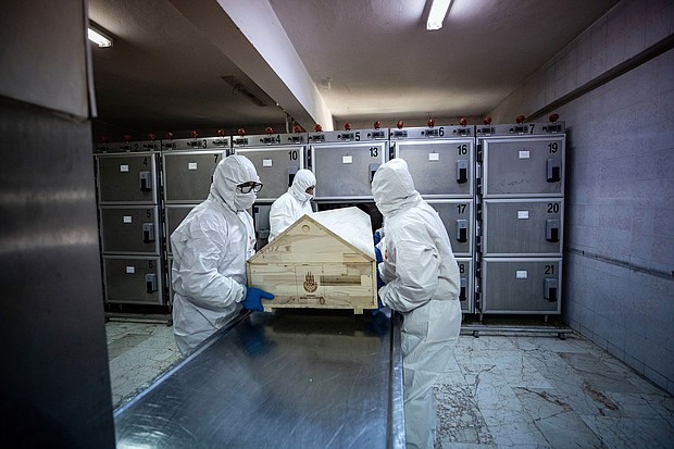 Officials with protective suits carry a coffin of a coronavirus victim before the process of ghusl, washing and shrouding the body, ahead of a Muslim funeral ceremony in Istanbul, Turkey, on May 10, 2020.
Credit:	Sebnem Coskun/Anadolu Agency/Getty Images