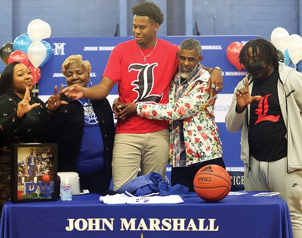 John Marshall High School basketball standout Roosevelt Wheeler, who at 6-foot-10 is one of the most recruited high school players in the nation, announces his decision to attend the University of Louisville on Monday in the North Side school’s gym. Joining him for the announcement celebration are, from left, his sister, Courtney Ingram of Atlanta; his mom, Deborah Davis of Richmond; his father, Roosevelt Wheeler Sr. of Atlanta; and his brother, C.J. Smith of Atlanta.