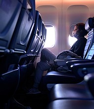 A masked passenger is seen seated on a flight from San Francisco, California to Newark, New Jersey on October 27, 2020.
Credit:	Michael Loccisano/Getty Images