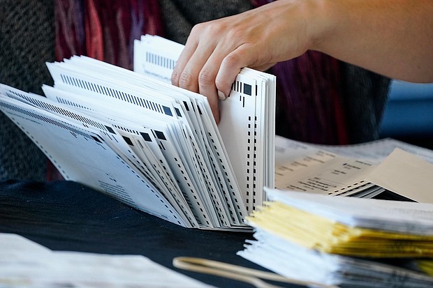 An election worker handles ballots as vote counting in the general election continues at State Farm Arena on November 5, 2020, in Atlanta.
Credit:	Brynn Anderson/AP