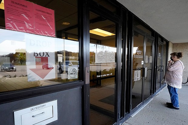 A woman checks information as information signs are displayed at IDES (Illinois Department of Employment Security) WorkNet center in Arlington Heights, Illinois on November 5, 2020.
Credit:	Nam Y. Huh/AP
