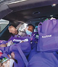 Ronald Jackson, 12, was among the volunteers who helped load cars, trucks and vans last Saturday with meals for veterans, seniors and families for Thanksgiving. The event at the Military Retirees Club in North Side was led by Richmond City Councilwoman Ellen F. Robertson, and was one of several food giveaways and feeding programs set up around the holiday. The young man attended the event with his mother, Tanya Jackson.