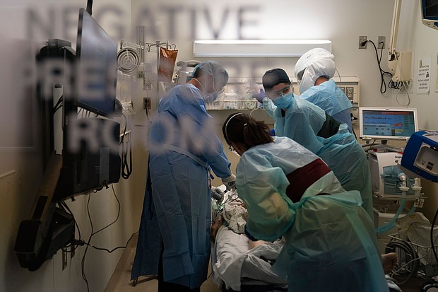 In this November 19, 2020, file photo, EMT Giselle Dorgalli, second from right, looks at a monitor while performing chest compression on a patient who tested positive for coronavirus in the emergency room at Providence Holy Cross Medical Center in the Mission Hills section of Los Angeles.
Credit: Jae C. Hong/AP