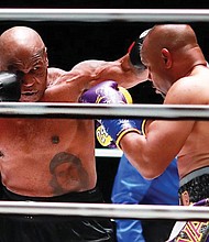 Mike Tyson, left, looks to land a punch on Roy Jones Jr. during their eight-round exhibition match Nov. 28 in Los Angeles.