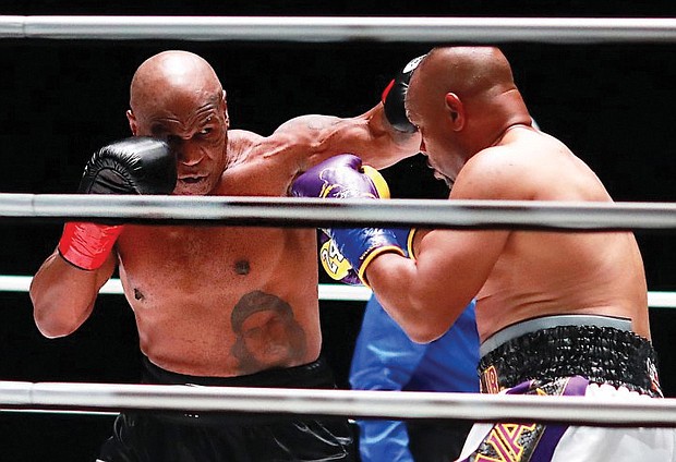 Mike Tyson, left, looks to land a punch on Roy Jones Jr. during their eight-round exhibition match Nov. 28 in Los Angeles.