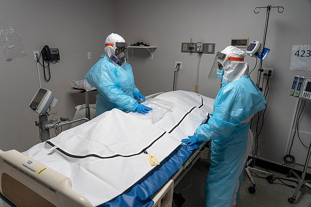 Medical staff members stand by a body bag that contains a deceased COVID-19 patient's body in the COVID-19 intensive care unit at the United Memorial Medical Center on November 25, 2020 in Houston, Texas.
Credit:	Go Nakamura/Getty Images