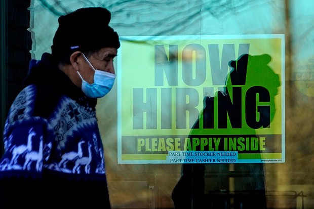 A shopper wears a face mask and he walks past a store displaying a hiring sign in Wheeling, IL.
	Nam Y. Huh/AP