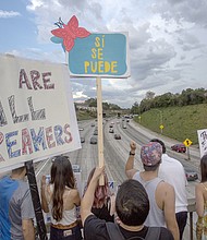 People hold signs over the 110 freeway as thousands of immigrants and supporters join the Defend DACA March to oppose the President Trump order to end DACA on Sept. 10, 2017 in Los Angeles.
Credit:	David McNew/Getty Images North America/Getty Images