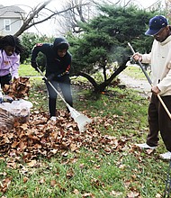 Cousins Armari Fells, 14, left, and Jeremiah Jefferson, 16, pitched in to help their grandfather, Tyrone Prentiss, spruce up the yard of his sister and her husband, Patrick and Delores Llewellyn, on brook Road in North Side. They took advantage of the sunshine last Saturday to rake and bag the leaves for pickup. Armari, who lives in Atlanta where his schooling is now virtual, has been visiting relatives in Richmond since Thanksgiving.