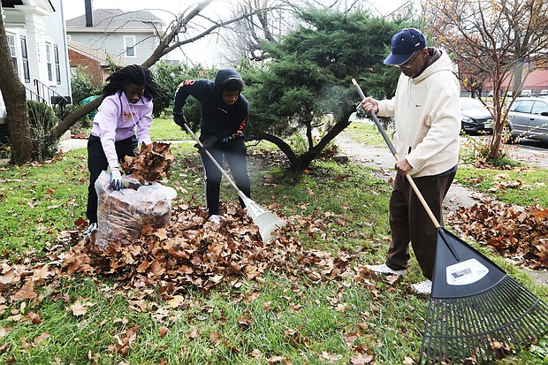 Cousins Armari Fells, 14, left, and Jeremiah Jefferson, 16, pitched in to help their grandfather, Tyrone Prentiss, spruce up the yard of his sister and her husband, Patrick and Delores Llewellyn, on brook Road in North Side. They took advantage of the sunshine last Saturday to rake and bag the leaves for pickup. Armari, who lives in Atlanta where his schooling is now virtual, has been visiting relatives in Richmond since Thanksgiving.