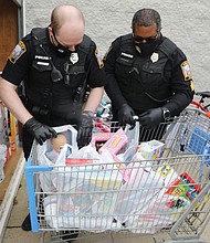 Officer Matt Wheeler, left, and Sgt. George Turner of the Chesterfield Police Department load donated toys into a storage container until they can be distributed.
