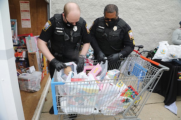 Officer Matt Wheeler, left, and Sgt. George Turner of the Chesterfield Police Department load donated toys into a storage container until they can be distributed.
