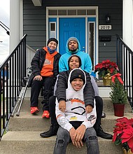 Spring Cambric, left, and her children, from the top, brandon, Kaila and Quentin enjoy the porch of their new home through Habitat for Humanity in the Chestnut Hills neighborhood in North Side.
