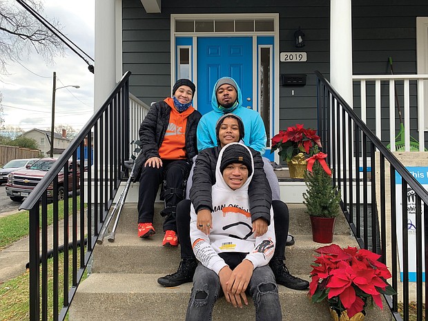 Spring Cambric, left, and her children, from the top, brandon, Kaila and Quentin enjoy the porch of their new home through Habitat for Humanity in the Chestnut Hills neighborhood in North Side.