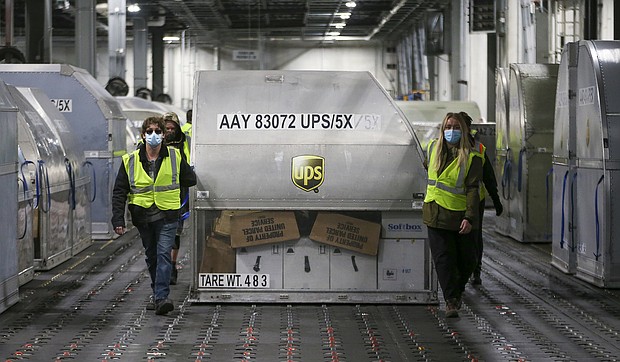 UPS employees move one of two shipping containers containing the first shipments of the Pfizer and BioNTech COVID-19 vaccine inside a sorting facility at UPS Worldport on December 13, 2020 in Louisville, Kentucky.
Credit:	Michael Clevenger/Pool/Getty Images