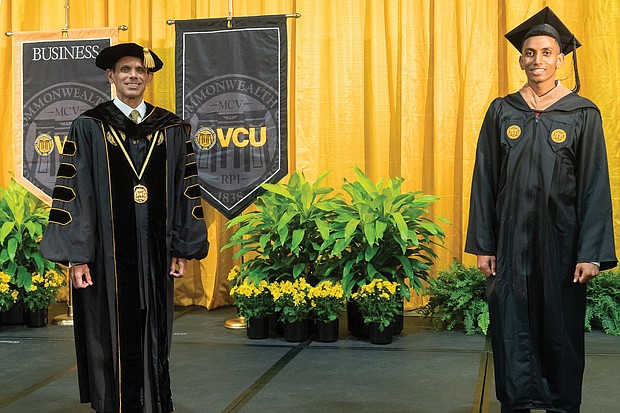 Virginia Commonwealth University President Michael Rao, left, practices social distancing with Solomon Workneh of Arlington. Mr. Workneh served as the inaugural student speaker at VCU’s 2020 winter commencement held online last Saturday.
