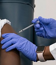Sandra Lindsay, left, a nurse at Long Island Jewish Medical Center, is inoculated with the COVID-19 vaccine by Dr. Michelle Chester, December 14, 2020  in the Queens borough of New York City.
Credit:	Mark Lennihan/Pool/Getty Images