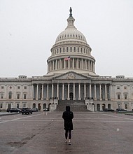 People walk past the US Capitol in Washington, DC on December 16, 2020.
Credit: Andrew Caballero-Reynolds/AFP/Getty Images