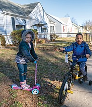 Gani brown, 4, and her older brother, Thi’yon Everhart, 5, try out their new wheels the day after Christmas near their grandmother’s house in the 500 block of Milton Avenue in North Side. More good weather for outdoor activities is expected before and after New Year’s Day, with temperatures expected to climb into the 60s on Saturday after rain showers on Jan. 1.