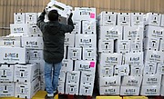 Paul Yoon, 49, of Midlothian organizes boxes of fresh greens as he and dozens of other volunteers prepare for the drive-thru food service to open at the Chesterfield Food Bank. Mr. Yoon has been volunteering with the feeding program since the pandemic’s start.