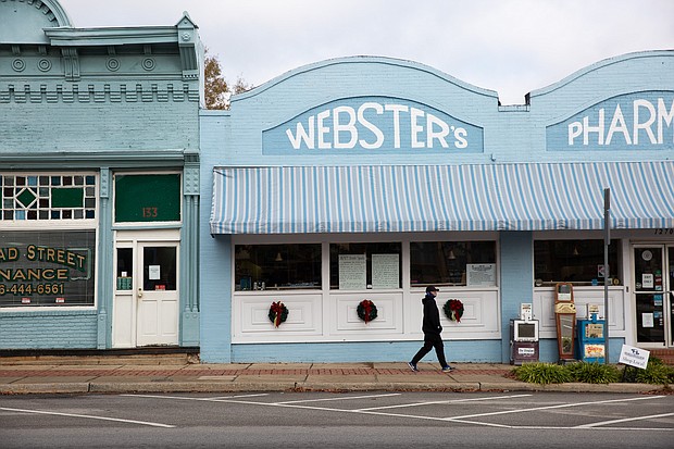 A person walks past a downtown Sparta pharmacy. A sign in its window urges residents to buy locally.
Credit:	Austin Steele/CNN