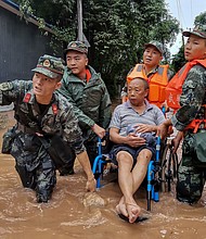 A resident is evacuated from a flooded street in Meishan in China's southwestern Sichuan province.
Credit:	STR/AFP/Getty Images