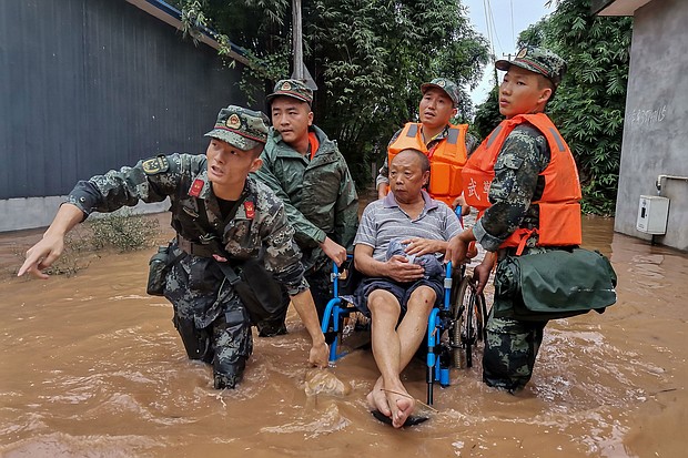 A resident is evacuated from a flooded street in Meishan in China's southwestern Sichuan province.
Credit:	STR/AFP/Getty Images
