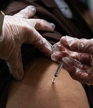 A pharmacist administers a dose of the Pfizer-BioNTech Covid-19 vaccine to a nursing home resident in the Bronx borough of New York on December 21, 2020.
Credit:	Eric Lee/Bloomberg/Getty Images