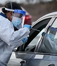 Nurse practitioner Deborah Beauplan administers a COVID-19 swab test at a drive-thru testing site set up for Suffolk County employees and their families at Smith Point Park in Shirley, New York on December 19, 2020. The CDC hopes to double the number of coronavirus samples checked for new mutations.
Credit:	Newsday via Getty Images
