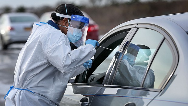 Nurse practitioner Deborah Beauplan administers a COVID-19 swab test at a drive-thru testing site set up for Suffolk County employees and their families at Smith Point Park in Shirley, New York on December 19, 2020. The CDC hopes to double the number of coronavirus samples checked for new mutations.
Credit:	Newsday via Getty Images