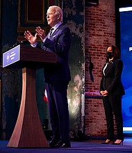President-elect Joe Biden speaks at The Queen theater on December 28, 2020, in Wilmington, Delaware. Vice President-elect Kamala Harris listens at right.
Credit:	Andrew Harnik/AP