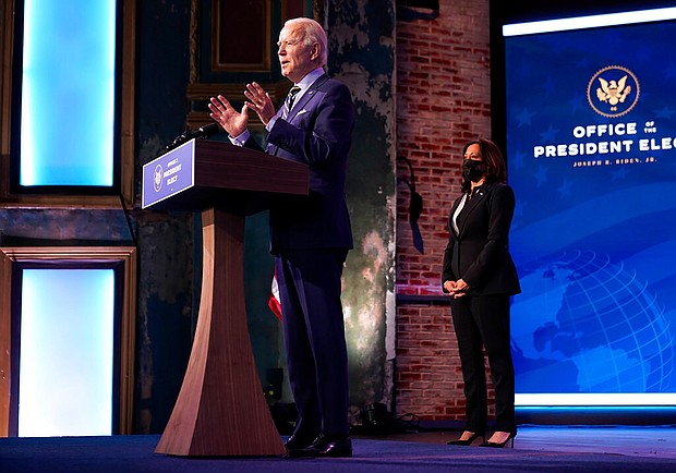President-elect Joe Biden speaks at The Queen theater on December 28, 2020, in Wilmington, Delaware. Vice President-elect Kamala Harris listens at right.
Credit:	Andrew Harnik/AP