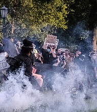 Protesters participating in a peaceful demonstration react to being hit by Richmond Police with tear gas and pepper spray on Monument Avenue at the Robert E. Lee statue about 30 minutes before the city’s 8 p.m. curfew on June 1.