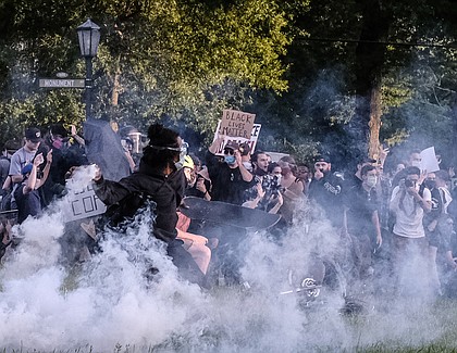 Protesters participating in a peaceful demonstration react to being hit by Richmond Police with tear gas and pepper spray on Monument Avenue at the Robert E. Lee statue about 30 minutes before the city’s 8 p.m. curfew on June 1.