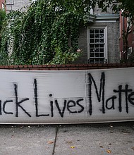 A “Black Lives Matter” banner hangs in October on the wall in front of a Monument Avenue residence near Allen Avenue, the epicenter of protests over racial injustice and police brutality since May. Signs like this one and logos with BLM have become commonplace on businesses and other buildings in and near Downtown and the Lee monument following an early spate of damage. The signs often were posted as a signal to spare the place from any damage.