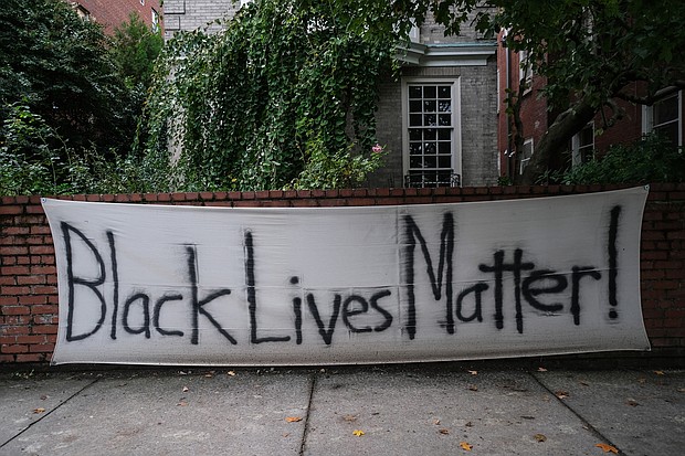 A “Black Lives Matter” banner hangs in October on the wall in front of a Monument Avenue residence near Allen Avenue, the epicenter of protests over racial injustice and police brutality since May. Signs like this one and logos with BLM have become commonplace on businesses and other buildings in and near Downtown and the Lee monument following an early spate of damage. The signs often were posted as a signal to spare the place from any damage.