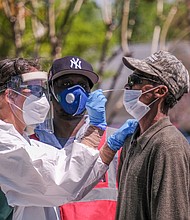 Lamire Balde is tested for the coronavirus by health care professionals at a Richmond Health District walk-up community testing event April 22 at the Southwood Apartments in South Side. Free COVID-19 tests have continued throughout the area.