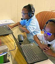 Chimborazo Elementary School students Kyle, 6, left, and Kevin Wilson, 8, connect with their teachers and classmates on Sept. 8, the first day of school, using Chromebooks provided by Richmond Public Schools. Kitchen tables have become virtual classrooms for many students, with parents monitoring schoolwork.