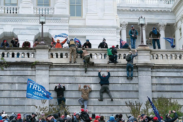 Supporters of President Trump scale the west wall of the U.S. Capitol on Wednesday before breaking windows and storming the building, where they took over the Senate and House chambers and several offices. Police finally secured the building around 6:20 p.m.