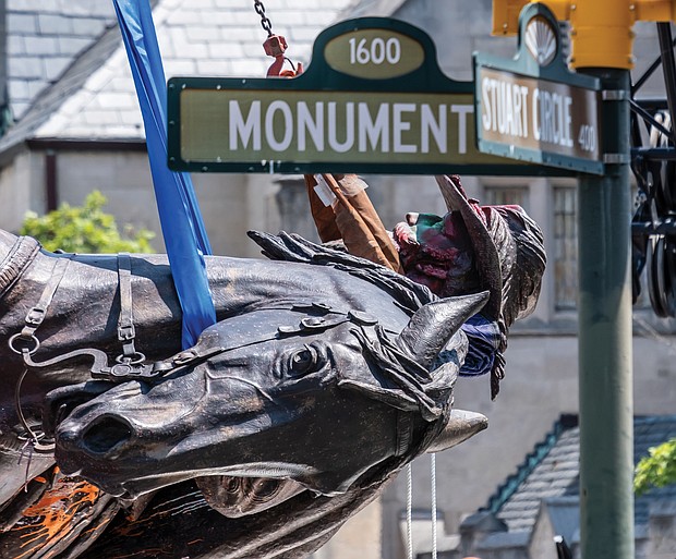 The statue of Confederate Gen. J.E.B. Stuart is turned on its side and lowered onto a flatbed truck on July 7 after being taken from its pedestal at Monument Avenue and Stuart Circle. It was sent to storage as the city worked out a plan for disposal.