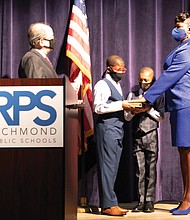 New Richmond School Board member Mariah L. White, 2nd District, is sworn in Monday by Richmond Circuit Court Clerk Edward F. Jewett with her sons, Lehman White, 12, left, and Alijah White, 9, holding the Bible. Mrs. White is among four new members on the nine-member board.