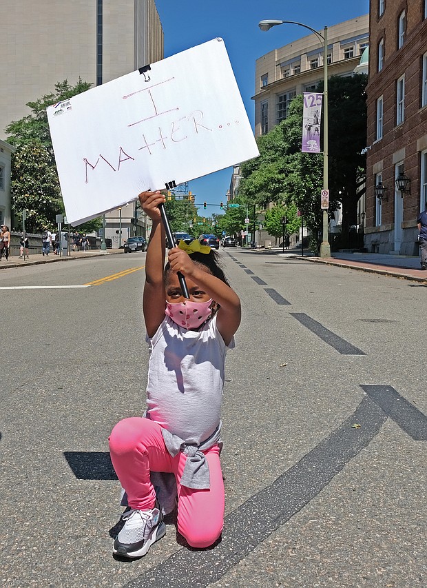 Nasiah Morris, 4, carries a sign with a powerful message during a peaceful grassroots march May 31 from Brown’s Island to the 17th Street Market in Shockoe Bottom. The youngster, kneeling at 9th and Grace streets across from the State Capitol, attended the rally with her mother, Toya Morris, and 15-year-old brother, Tye.