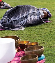 Treasure Daily, 10, is bundled up in the outfield of The Diamond listening as her mother, Shanna Latia, conducts sound therapy during Project Yoga Richmond’s Saturday Salutations on Sept. 19. The nonprofit organization has worked to make yoga affordable and accessible to Richmonders, particularly during the current high- stress times.