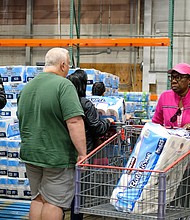 Customers flock to the pallets of toilet paper at Costco on March 14 as the initial threat of coronavirus and a statewide shutdown causes consumers to make a run on paper products, cleaning supplies and food staples at area stores.