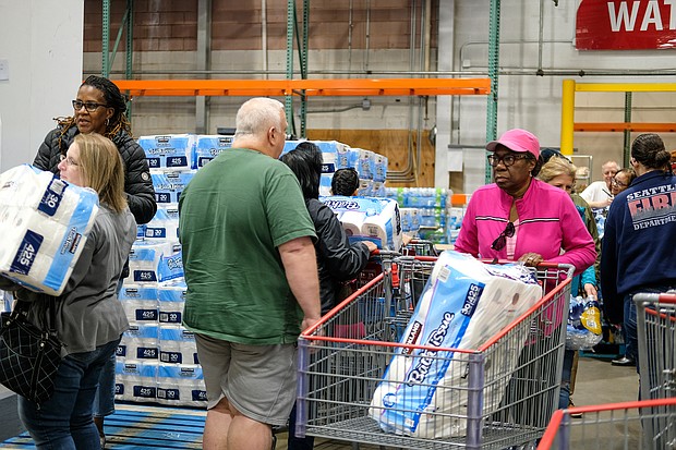 Customers flock to the pallets of toilet paper at Costco on March 14 as the initial threat of coronavirus and a statewide shutdown causes consumers to make a run on paper products, cleaning supplies and food staples at area stores.